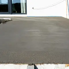 Świeżo wylany beton na tarasie czeka na wykończenie. Trwa naprawa tarasu betonowego, by znów był jak nowy.