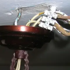 Podłączanie żyrandola na 3 żarówki: widoczne przewody i kostka elektryczna przy suficie.