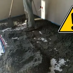 Prace przy wylewce podłogowej. Widać piasek i cement, przygotowanie do dylatacji posadzki.