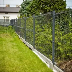 Nowy, nowoczesny płot panelowy oddziela zadbany trawnik od zieleni. Czy można postawić płot przy płocie? Tak, jeśli sąsiad ma taki sam!