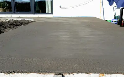 Świeżo wylany beton na tarasie czeka na wykończenie. Trwa naprawa tarasu betonowego, by znów był jak nowy.