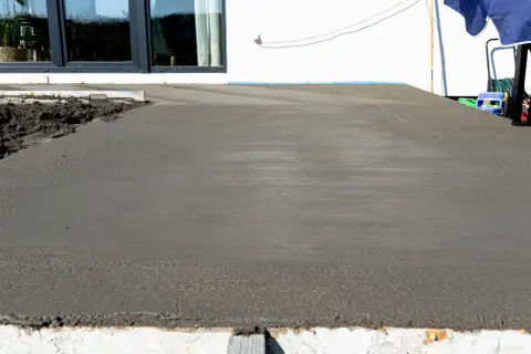 Świeżo wylany beton na tarasie czeka na wykończenie. Trwa naprawa tarasu betonowego, by znów był jak nowy.