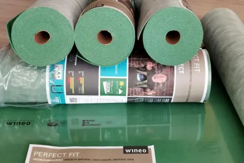 Rolki zielonego podkładu pod panele, idealne do ogrzewania podłogowego. Materiał "Perfect Fit" od wineo zapewnia komfort i izolację.