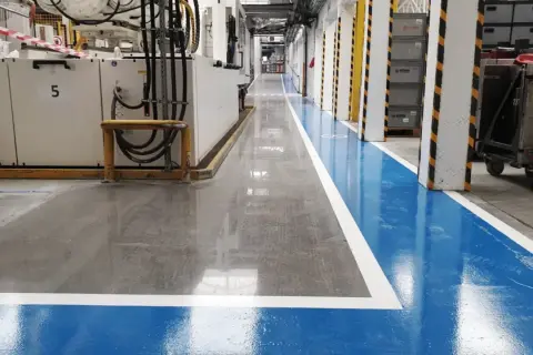 Nowa, lśniąca posadzka betonowa w hali produkcyjnej. Dowiedz się, jak wyrównać posadzkę betonową, by uzyskać taki efekt.