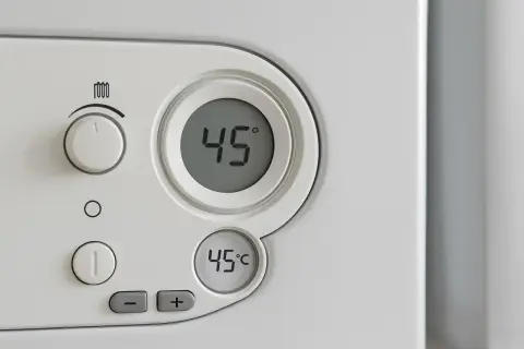 Panel sterowania pieca gazowego kondensacyjnego. Cyfrowy wyświetlacz pokazuje 45°C. Ustawienie temperatury na piecu gazowym kondensacyjnym.