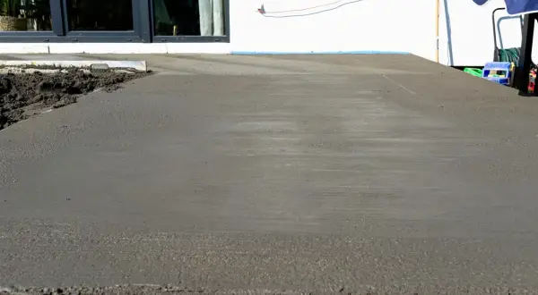 Świeżo wylany beton na tarasie czeka na wykończenie. Trwa naprawa tarasu betonowego, by znów był jak nowy.