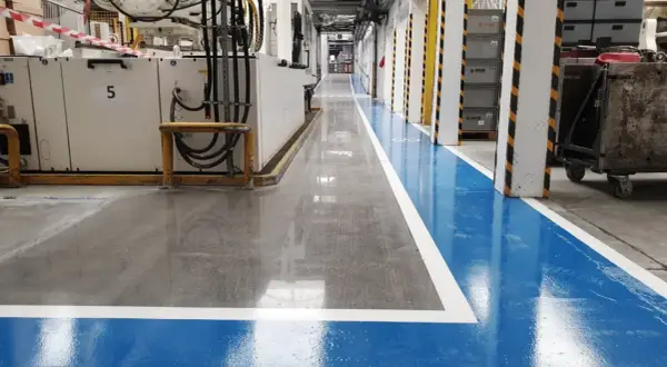 Nowa, lśniąca posadzka betonowa w hali produkcyjnej. Dowiedz się, jak wyrównać posadzkę betonową, by uzyskać taki efekt.