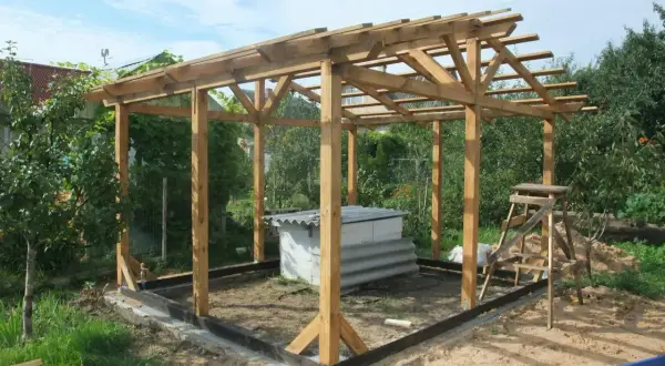 Drewniana altana ogrodowa 3x4 w trakcie budowy. W środku znajduje się biała konstrukcja z blachą falistą.
