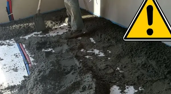 Prace przy wylewce podłogowej. Widać piasek i cement, przygotowanie do dylatacji posadzki.