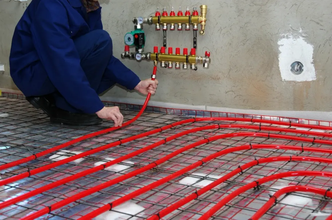 Instalator układa rury podłogówki, dobierając odpowiedni rozdzielacz do ogrzewania 100m2.