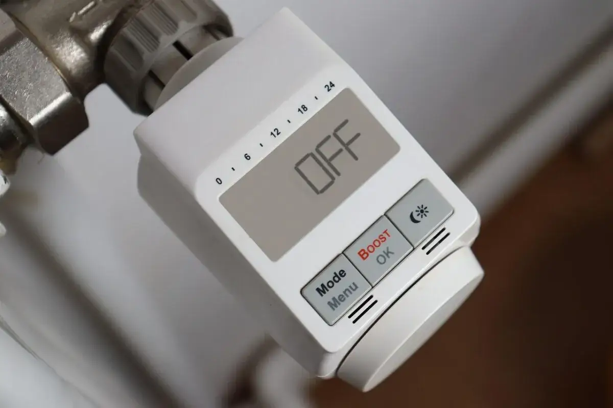 Biały termostat grzejnikowy, jedno z urządzeń IoT, pokazuje