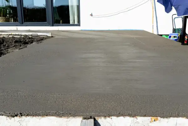 Świeżo wylany beton na tarasie czeka na wykończenie. Trwa naprawa tarasu betonowego, by znów był jak nowy.