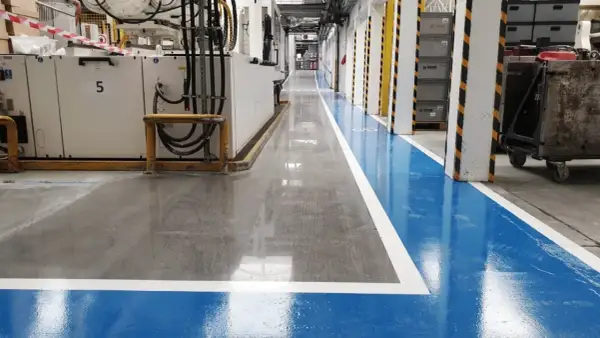 Nowa, lśniąca posadzka betonowa w hali produkcyjnej. Dowiedz się, jak wyrównać posadzkę betonową, by uzyskać taki efekt.